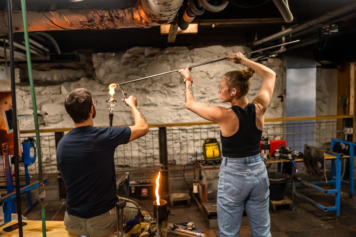 Two other glassblowers in the workshop.<br>